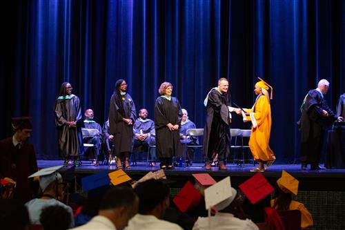 Graduate shaking Mr. Hendrick's hand